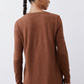 Back view of rust-brown V-neck long-sleeve top with curved longer hem