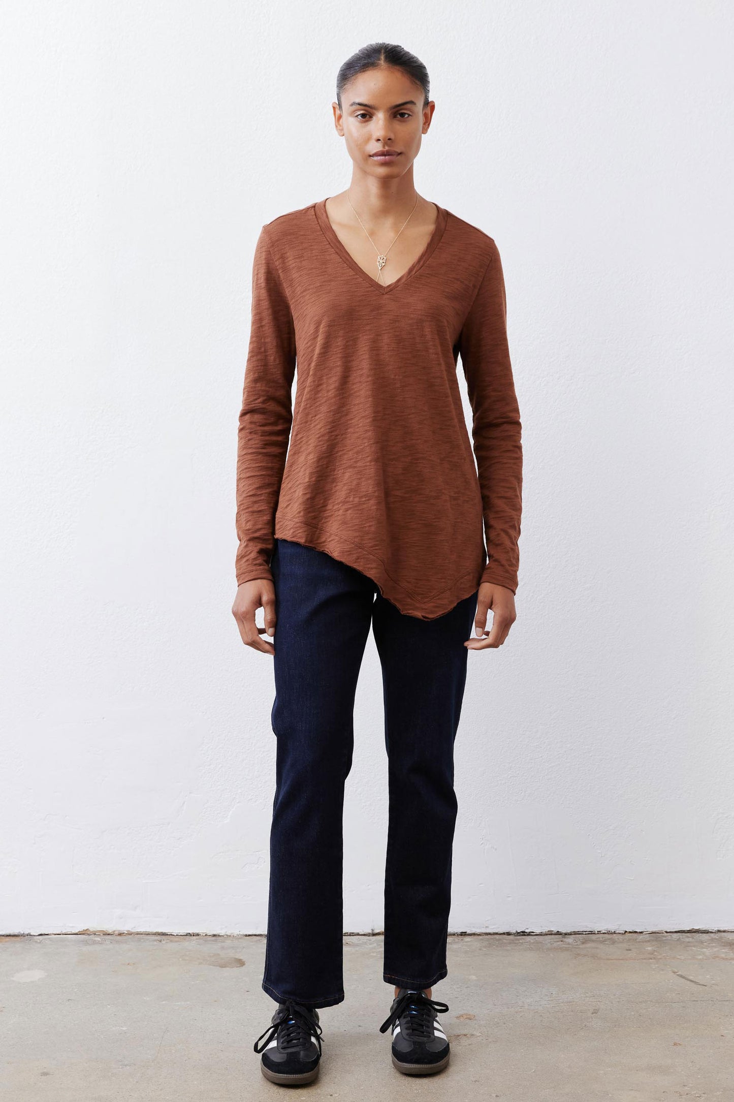 Bark brown v-neck long sleeve top with relaxed fit and curved hemline