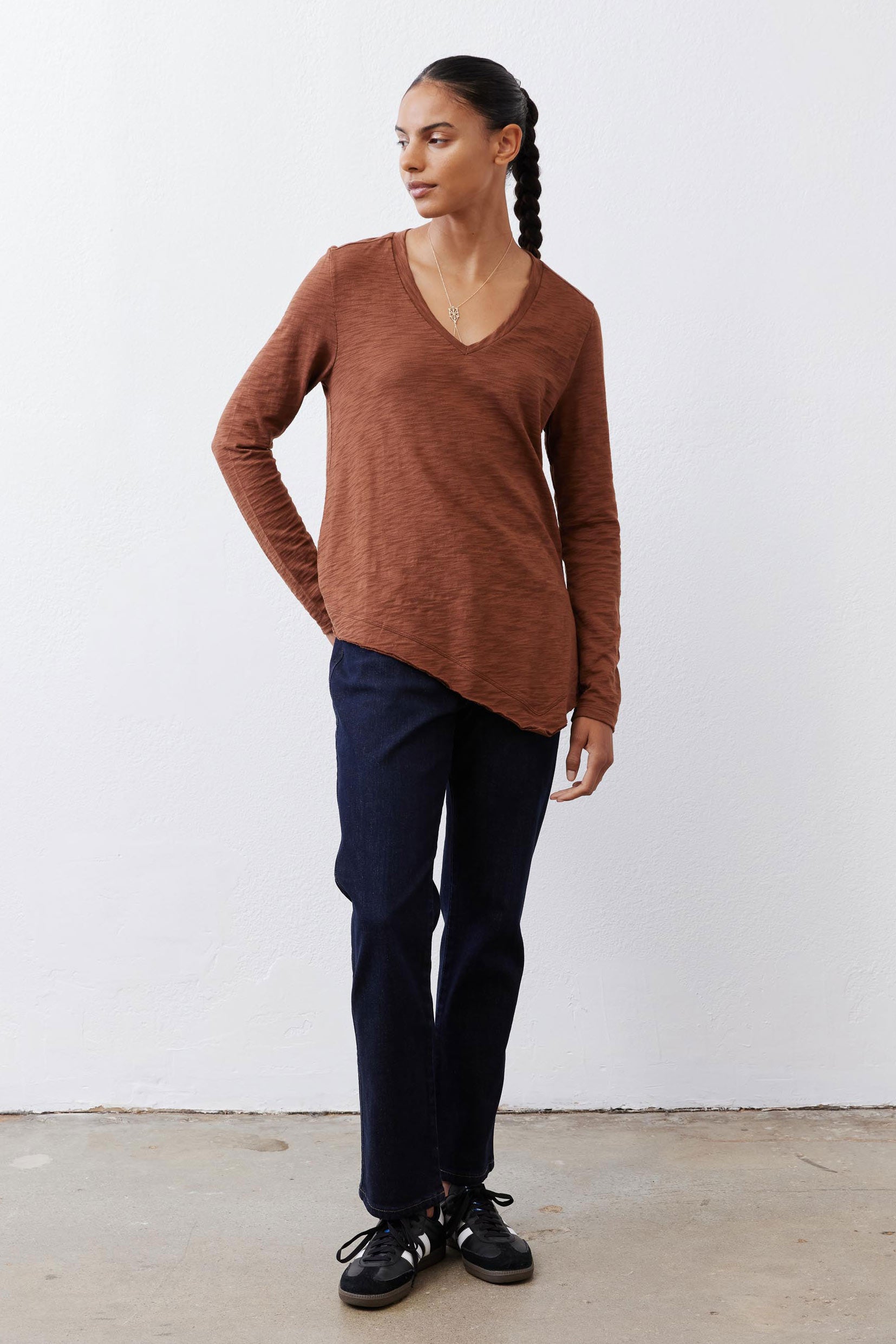 Bark brown v-neck long sleeve top with curved hem and draped relaxed fit