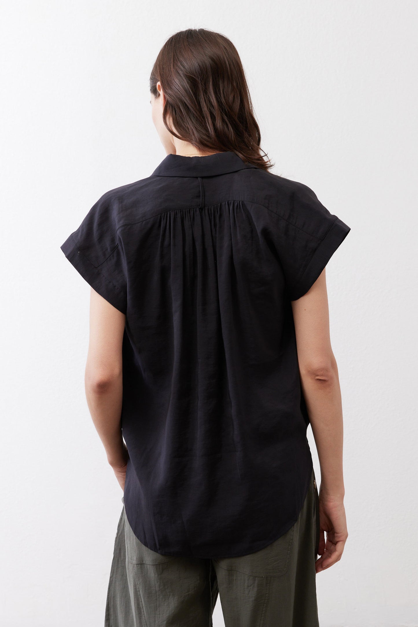 Black back of oversized voile blouse with pleated yoke and short sleeves