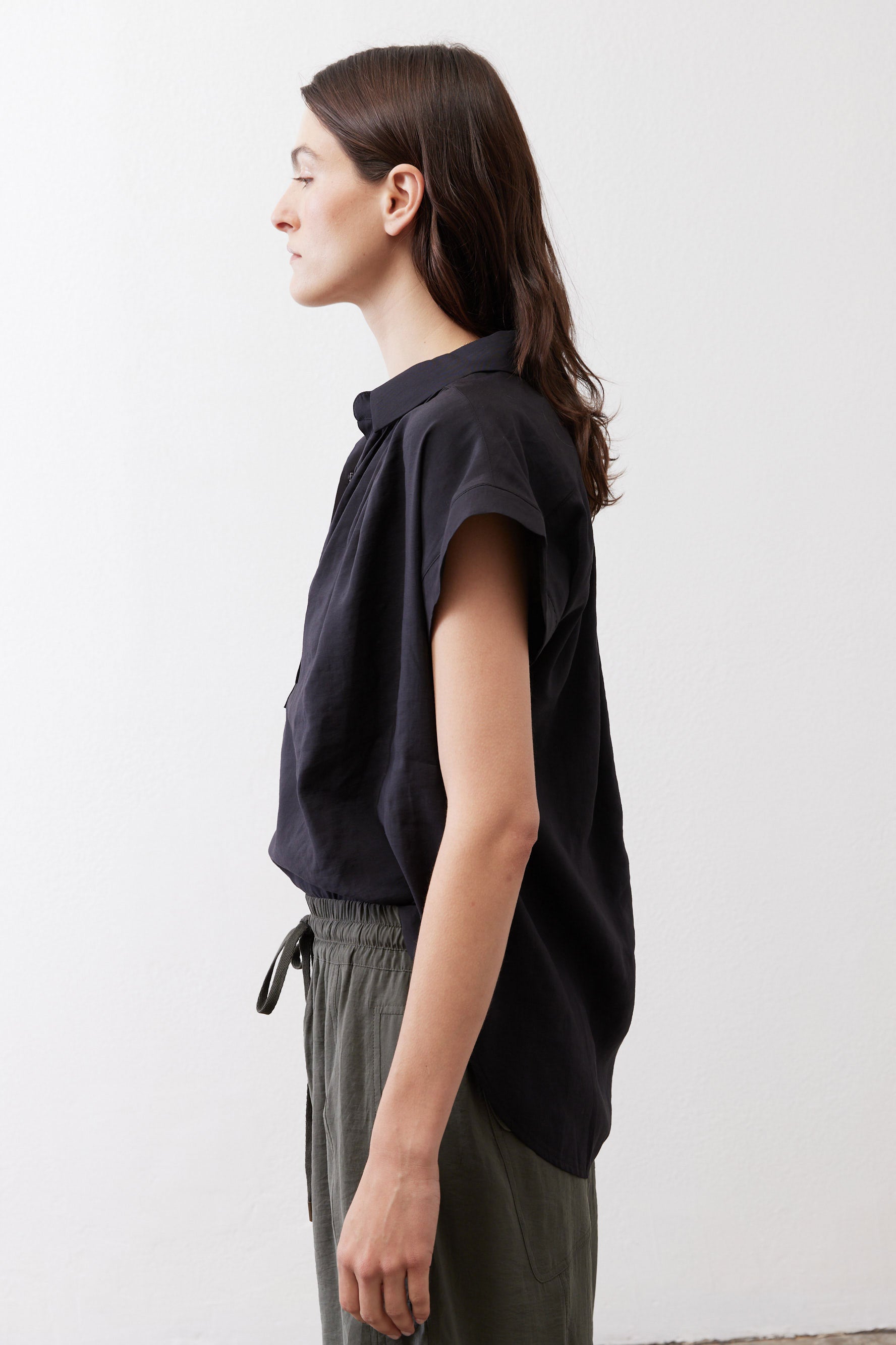 Black oversized blouse, short sleeves, relaxed fit, side view with button placket