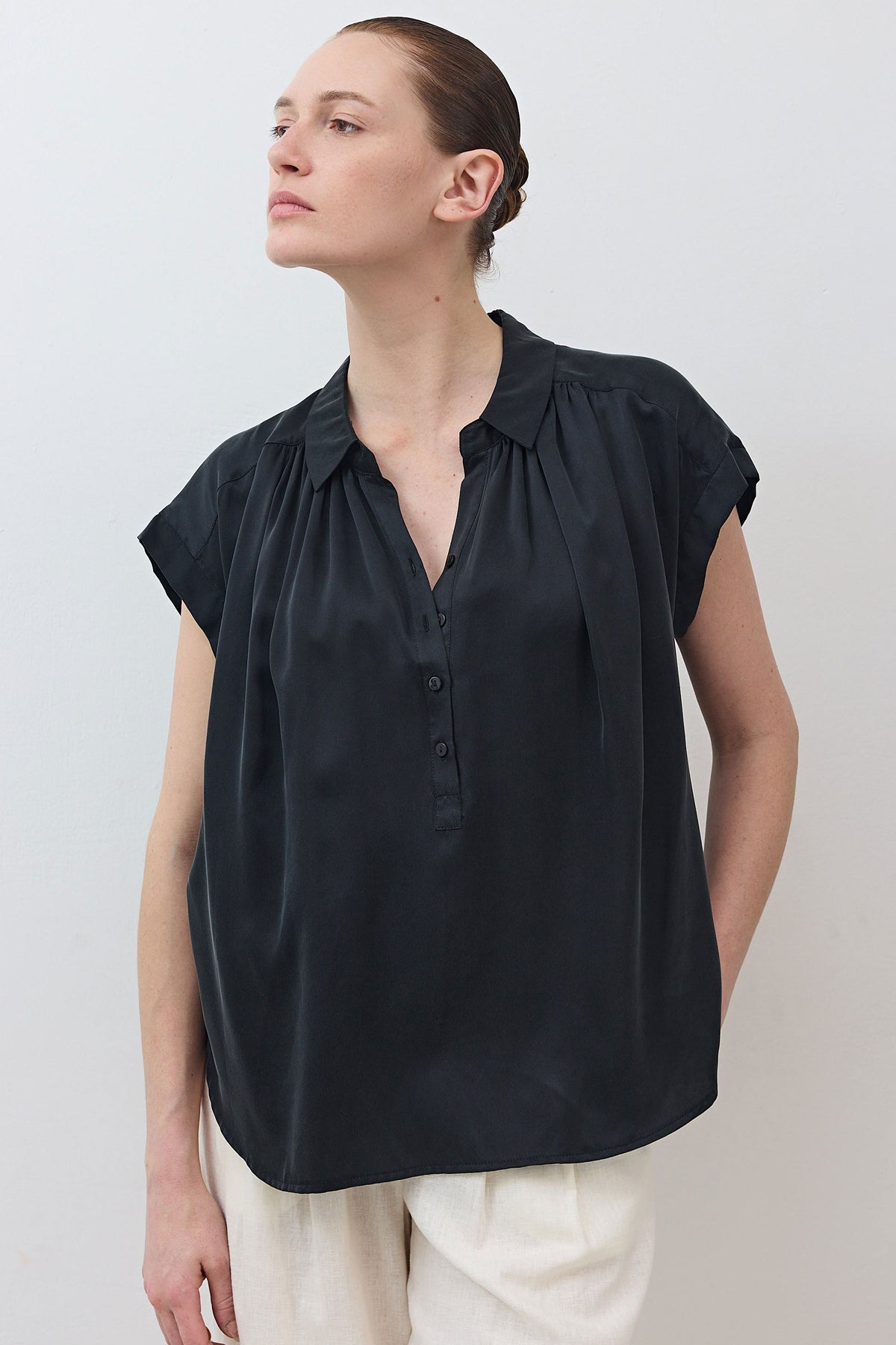 Black oversized silk blouse with gathered shoulder detail and button front
