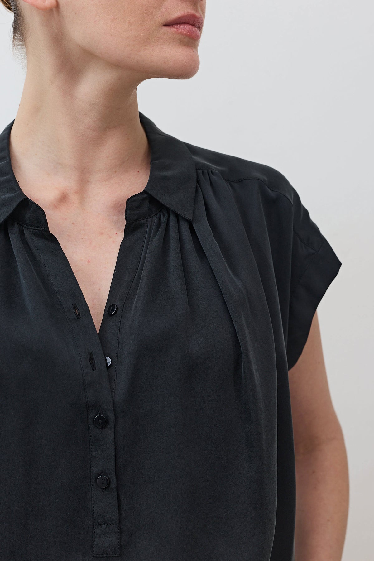 Black silk blouse neckline with button placket and gathered shoulder detail