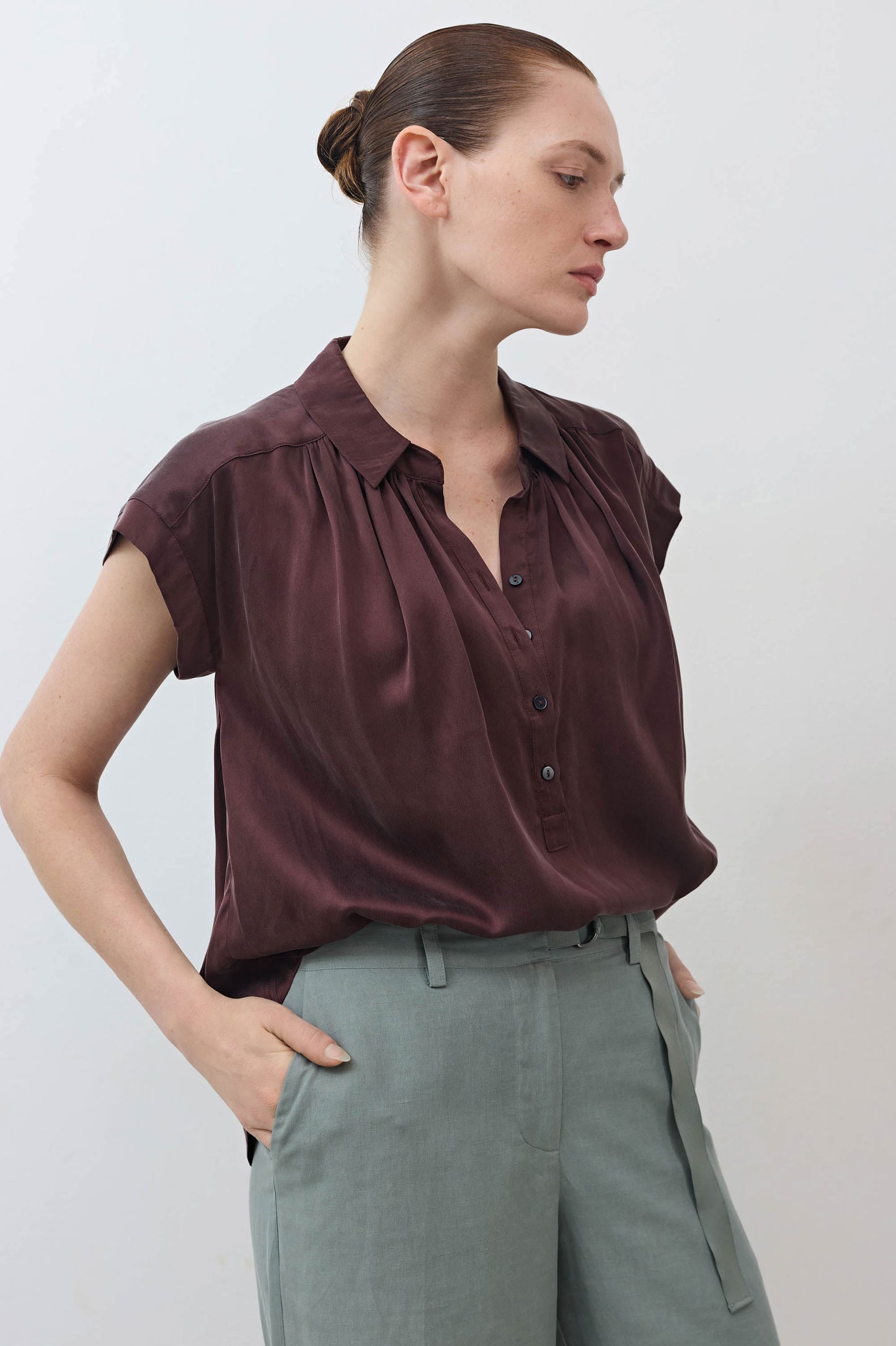 Maroon silk blouse with short sleeves, button front, and pleated neckline