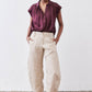 Malbec oversized silk blouse with short sleeves and button-front; worn with light pants