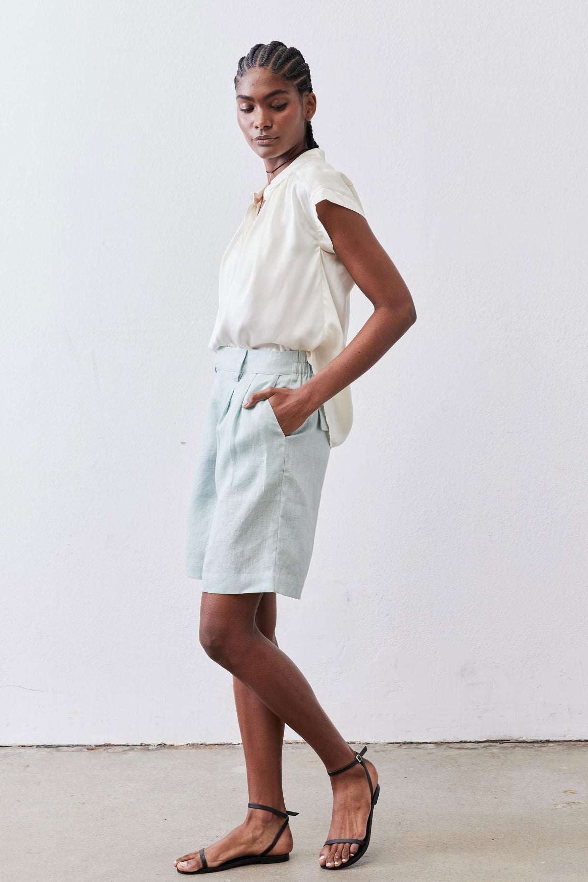 Mint pleated bermuda shorts, side view, mid-thigh length
