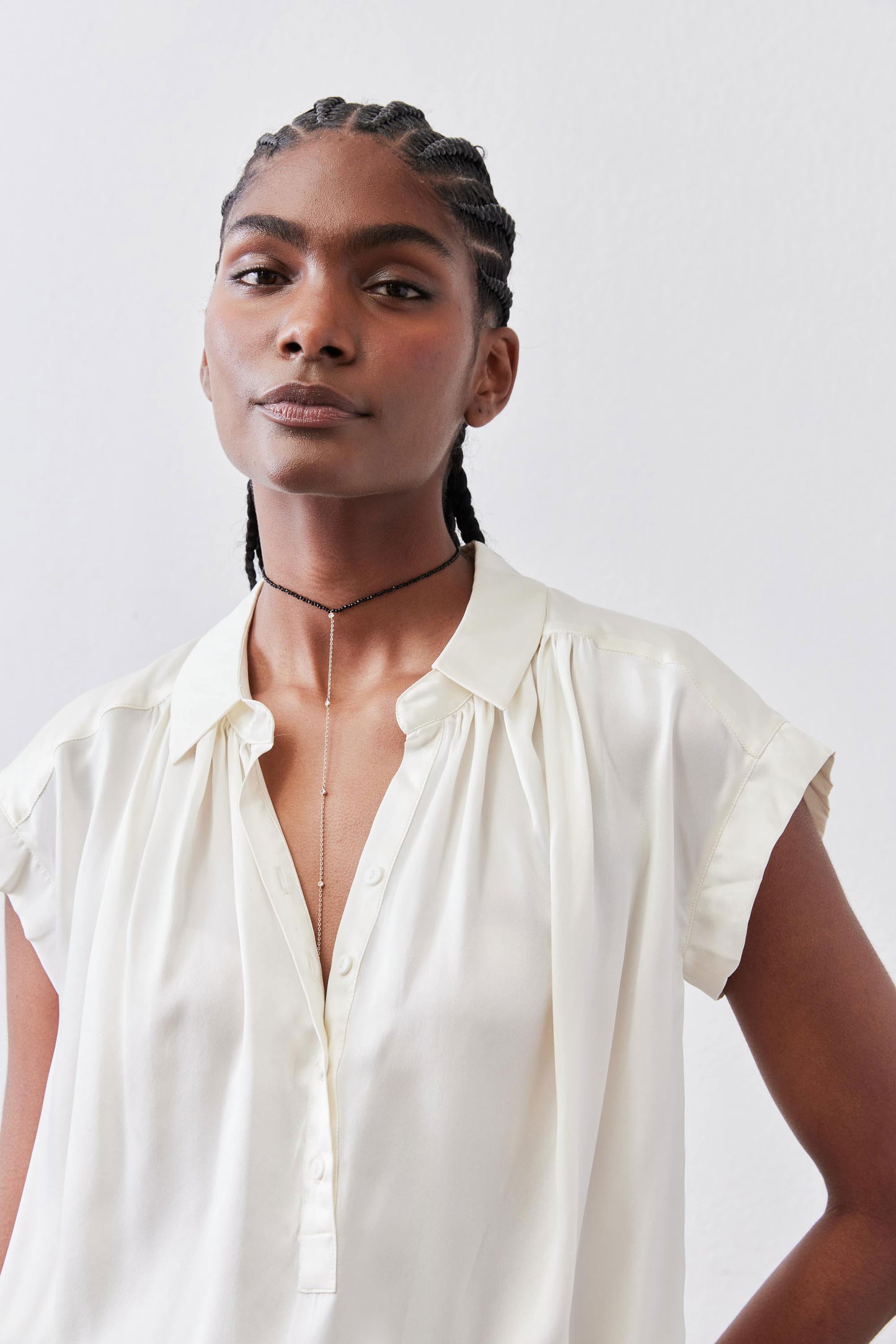 Ivory silk blouse with collarless split neckline and short buttoned front