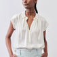 Ivory oversized silk blouse with short sleeves and front button placket