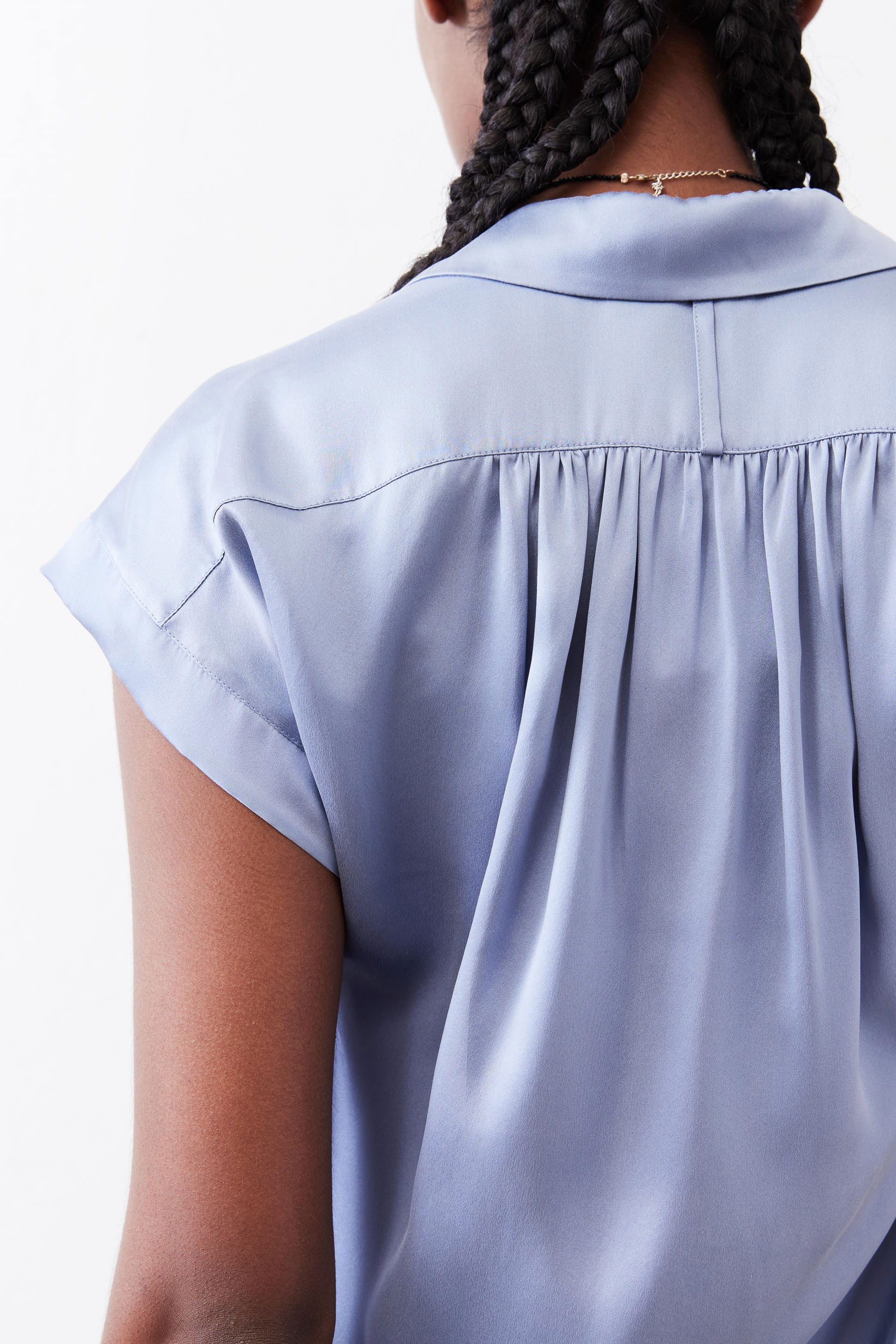 Steel blue silk blouse back with pleated yoke and gathered seam detail.