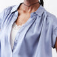 Steel blue silk blouse neckline with V-cut button front and lace underlay.