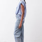 Steel blue silk blouse with short sleeves and draped shoulders, side profile.