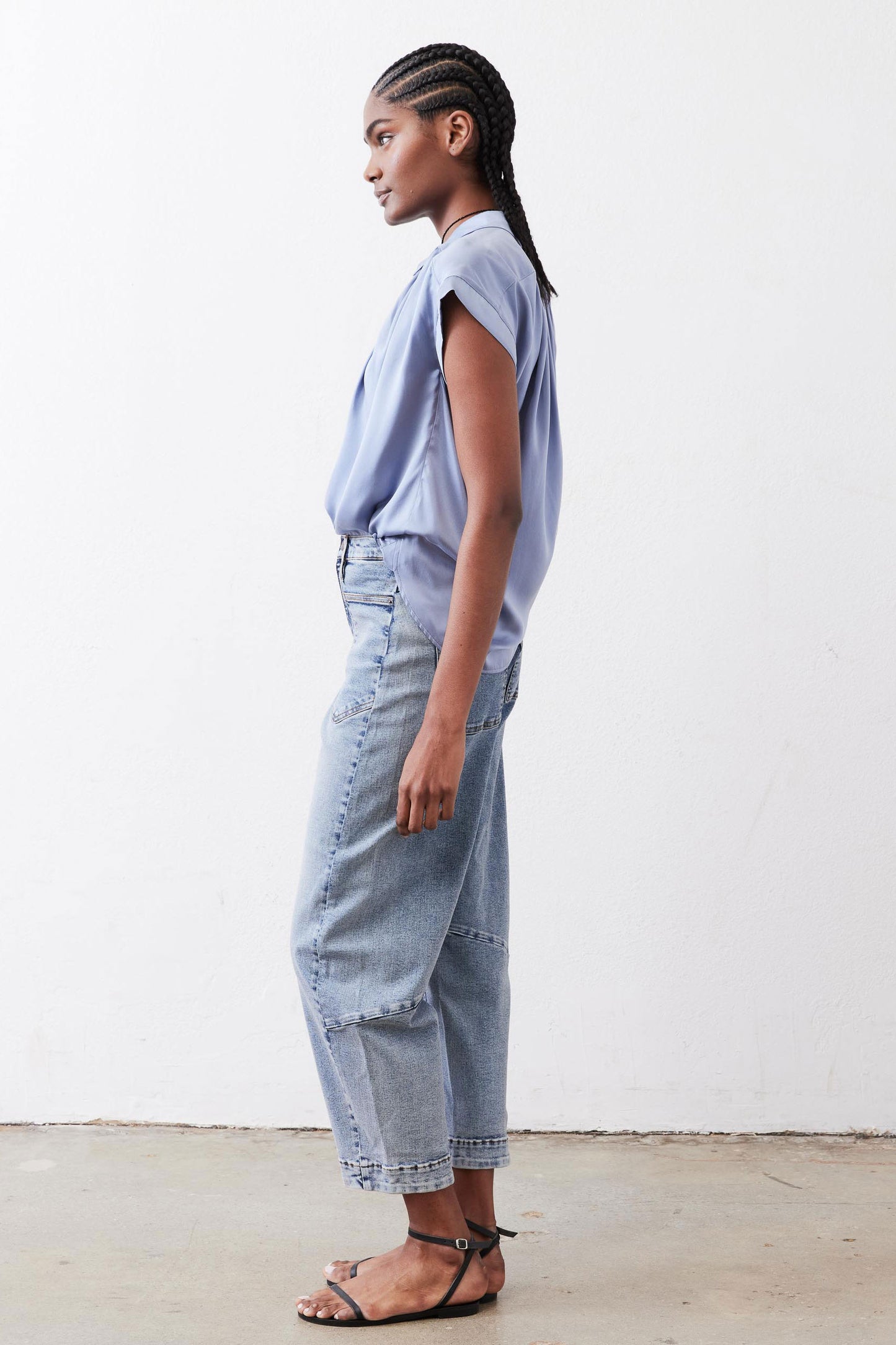 Steel blue silk blouse with short sleeves and draped shoulders, side profile.