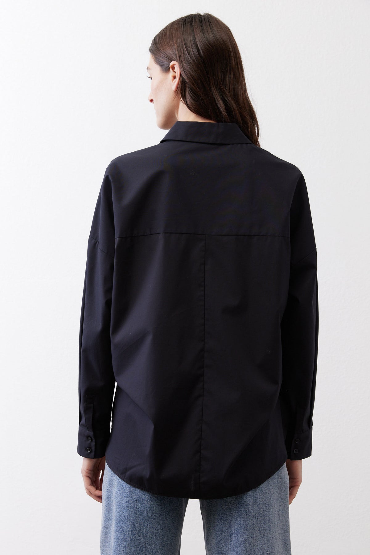 Black oversized tunic back view with yoke seam and stand point collar