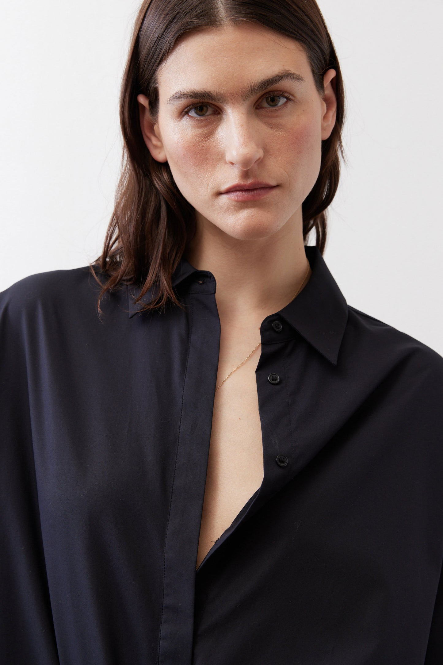 Black oversized tunic close-up with point collar and button placket