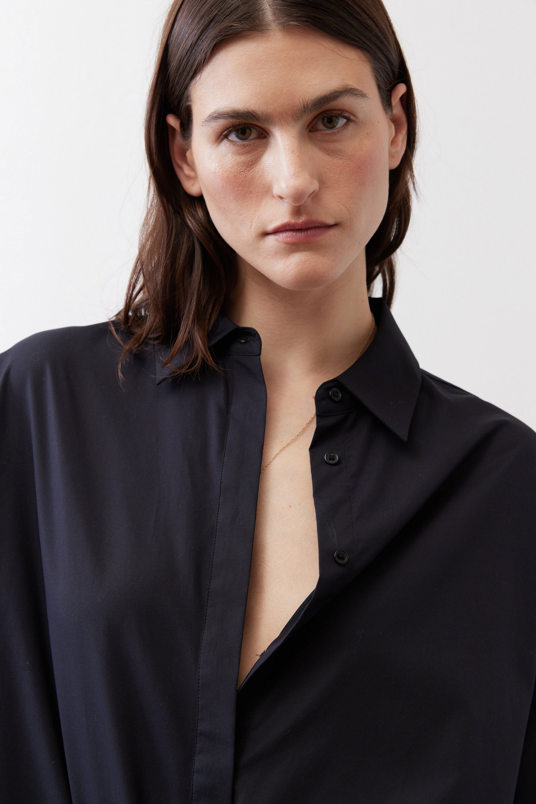 Black oversized tunic close-up with point collar and button placket