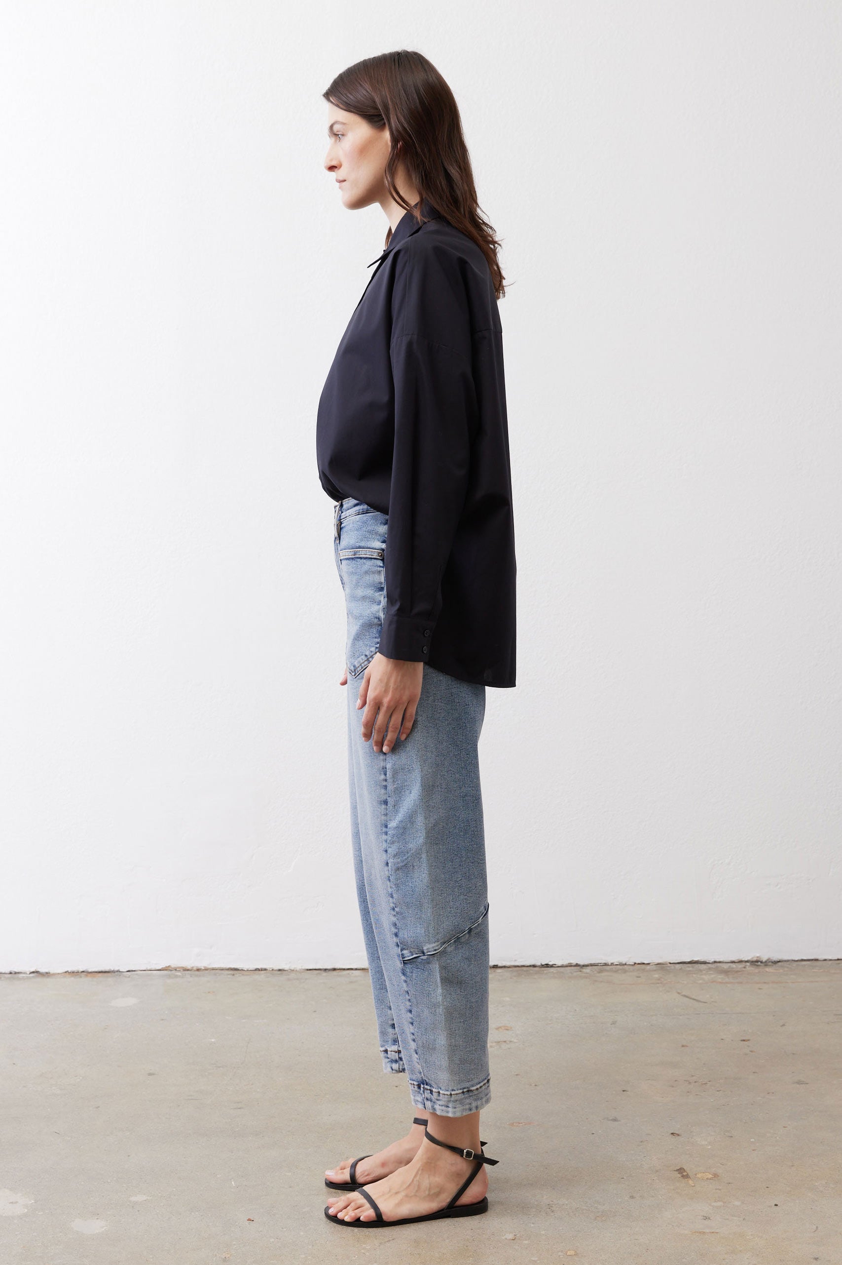 Black oversized tunic side view with point collar and button-front, long sleeves