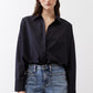 Black oversized tunic front view with point collar and button-front, long sleeves