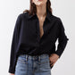 Black oversized tunic with point collar, open neckline, and button-front