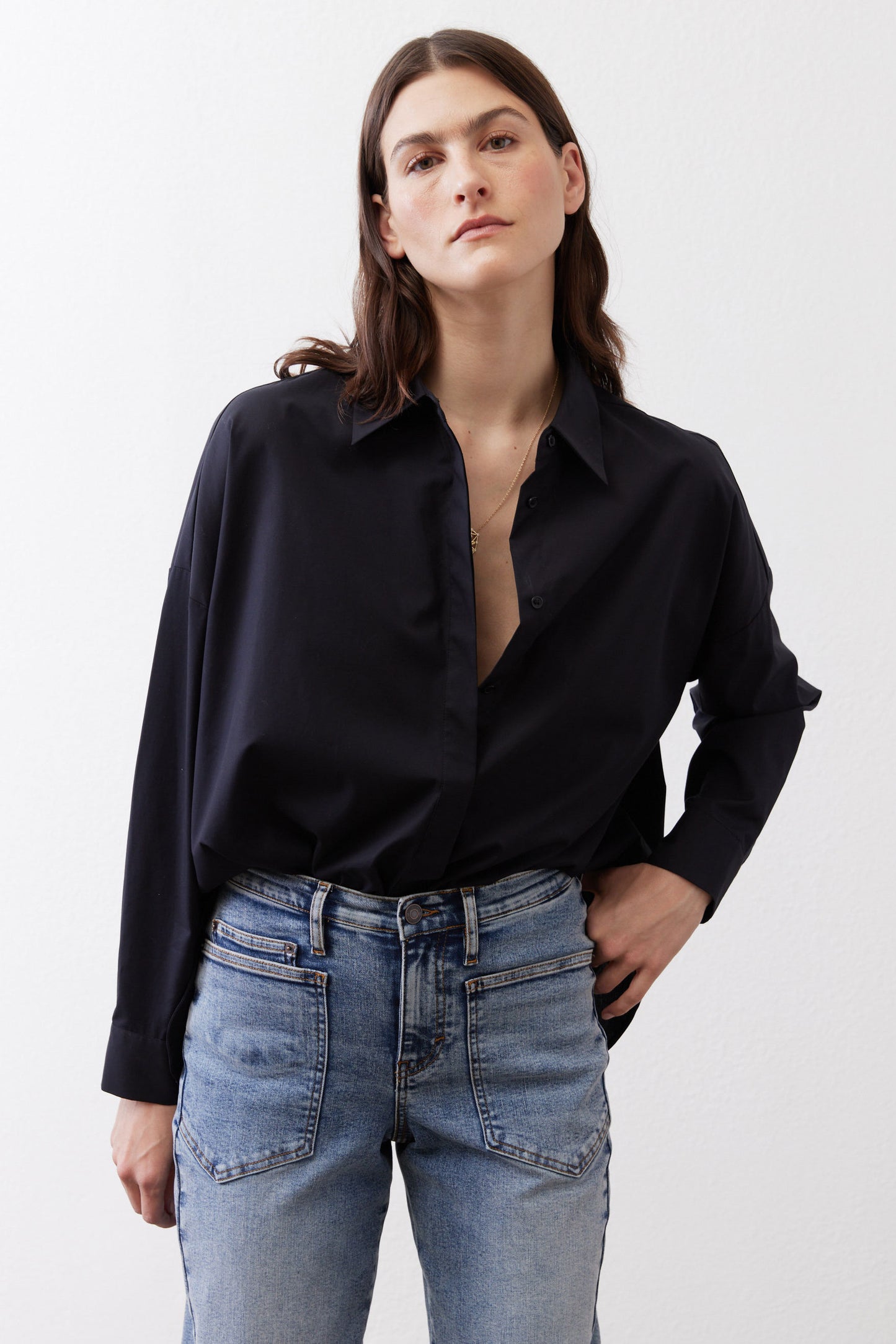 Black oversized tunic with point collar, open neckline, and button-front
