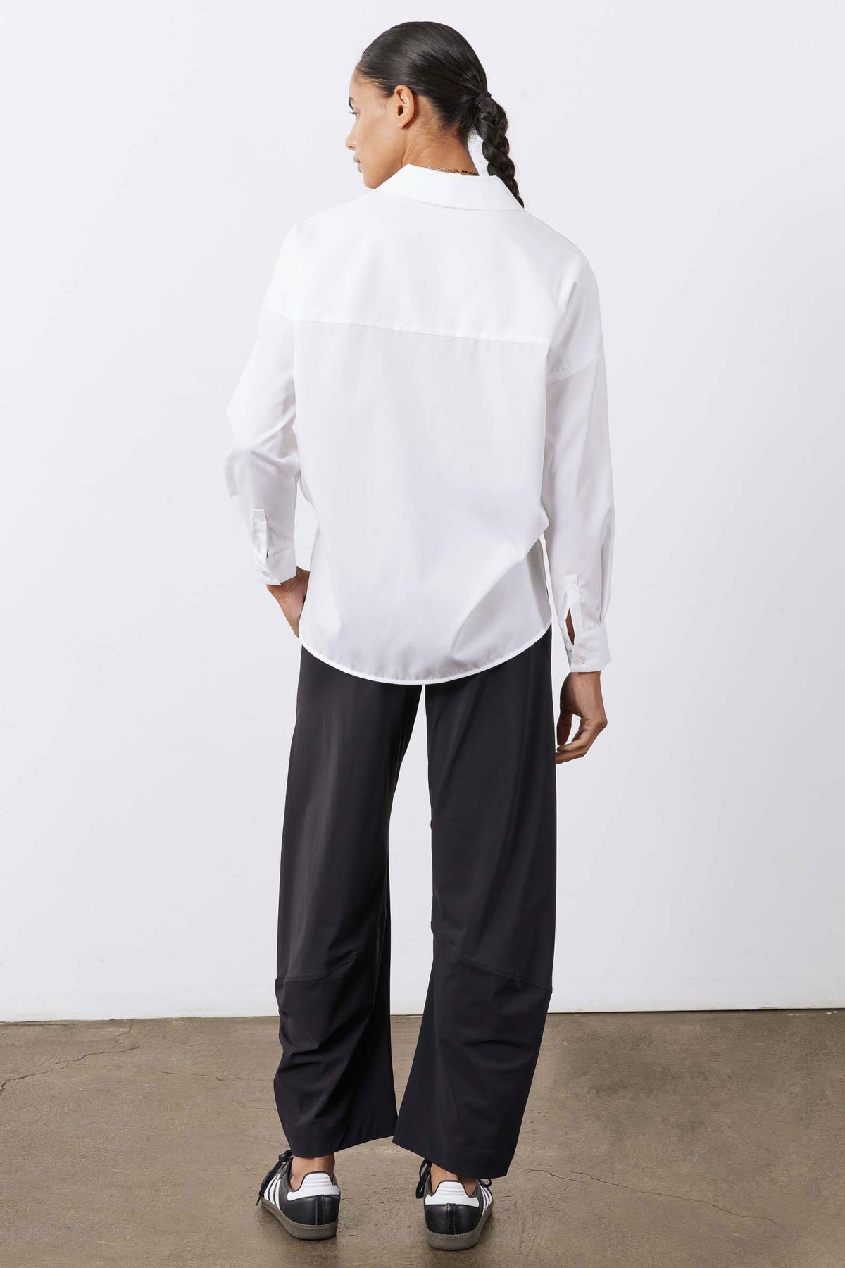 White oversized tunic shirt back view with long sleeves and buttoned yoke