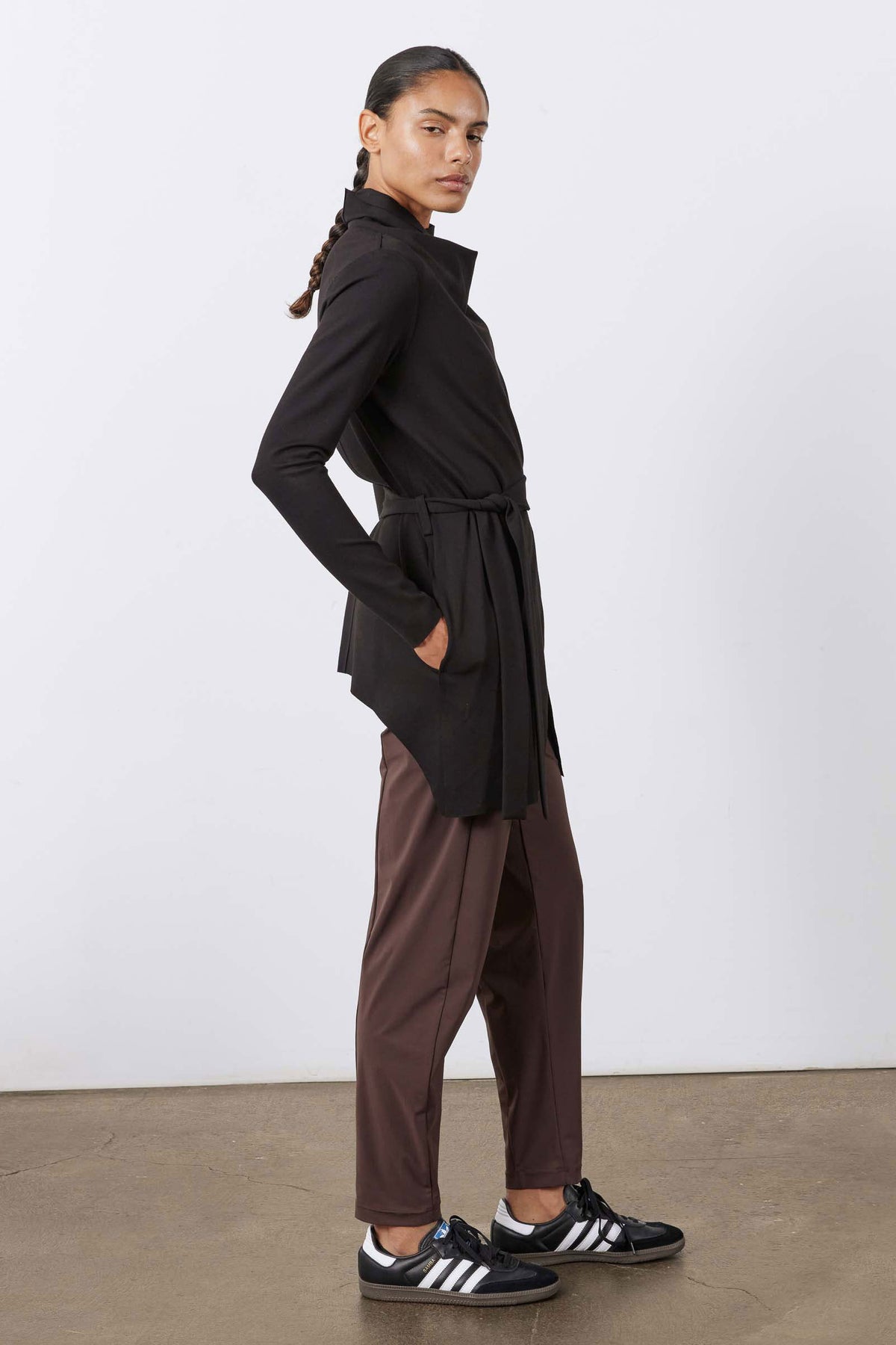 Coffee-brown not-too-tapered pants with tied waist and slash pockets, worn with sneakers