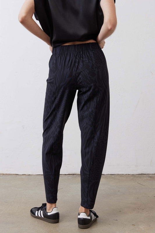 Dark navy animal-print tapered pants with elastic waist and relaxed back drape