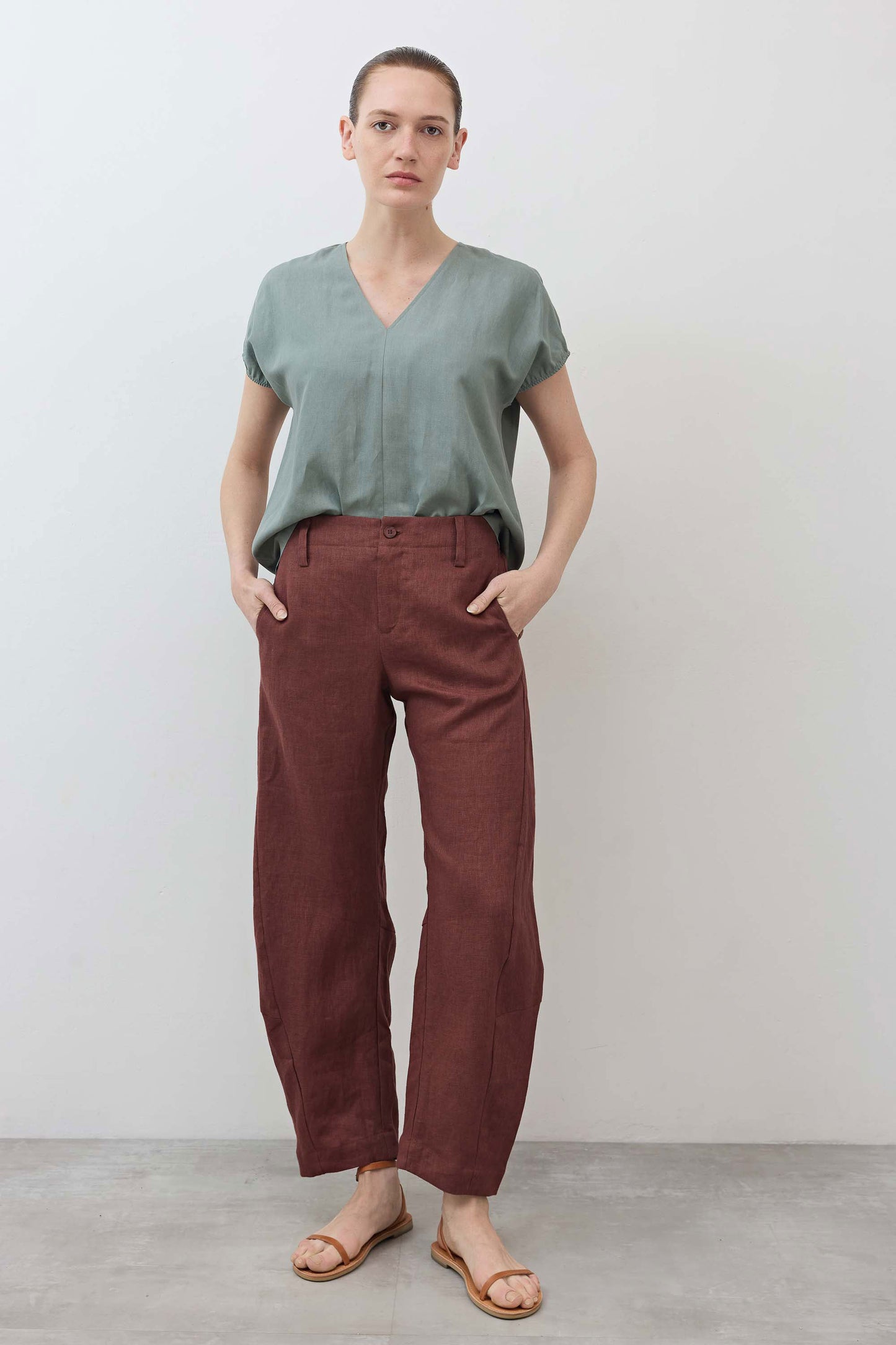 Spice brown loose linen pants front view with button placket, belt loops, and pockets