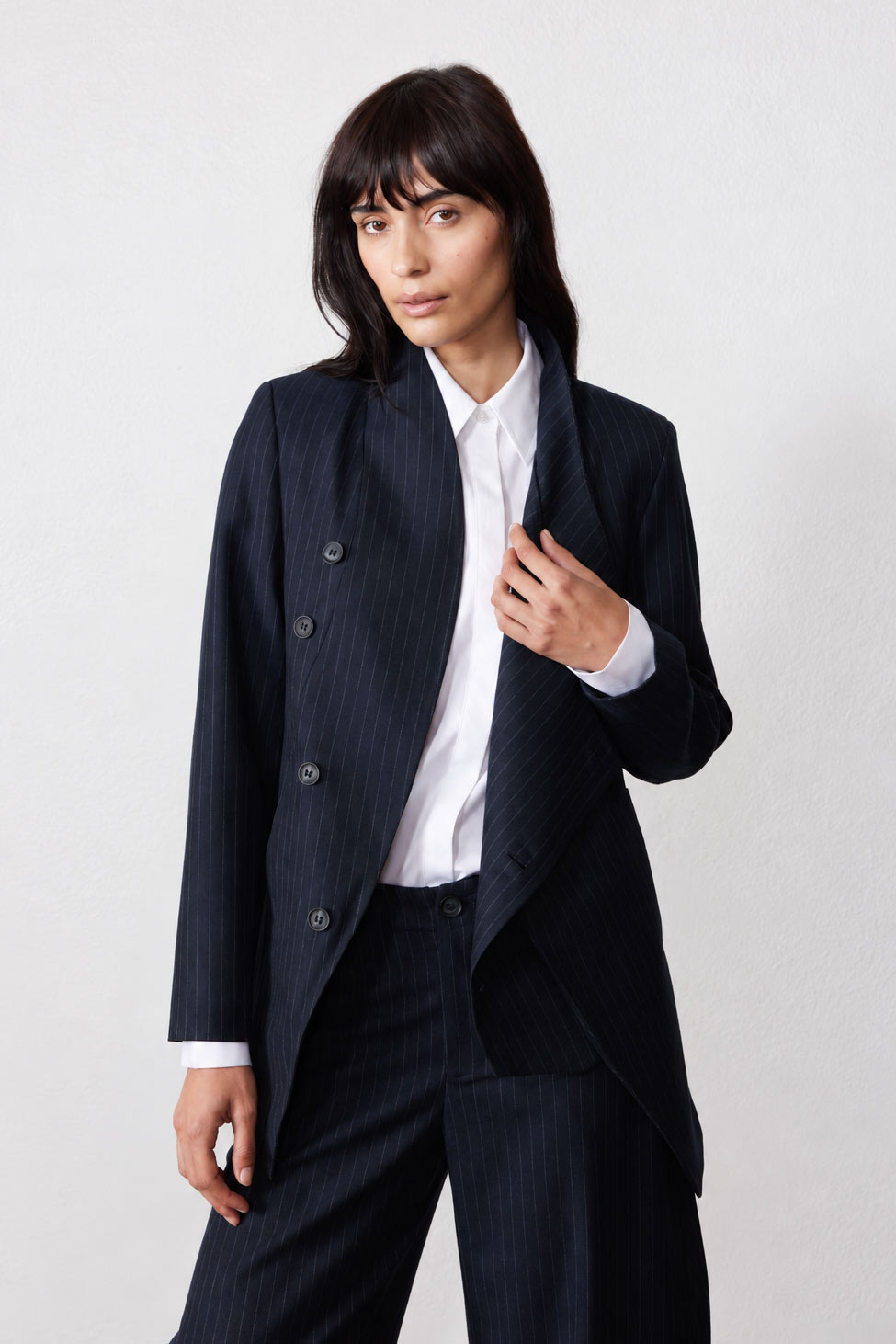 Navy pinstripe asymmetric suit jacket, open lapel and button placket, long sleeves