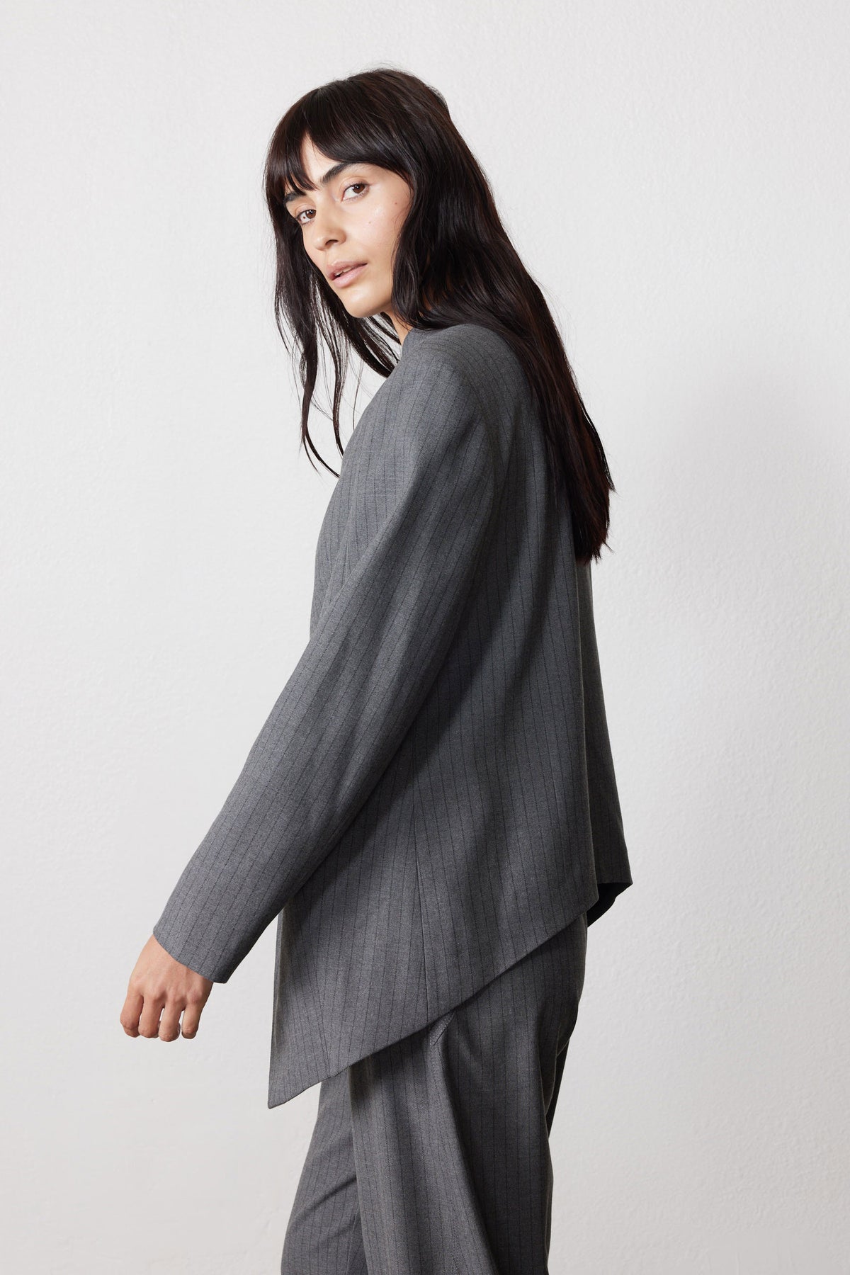 Gray pinstripe asymmetric suit jacket with long side-draped back hem