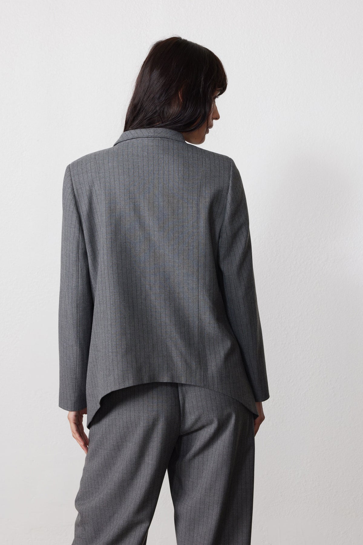 Gray pinstripe asymmetric suit jacket, back view with smooth yoke and long sleeves