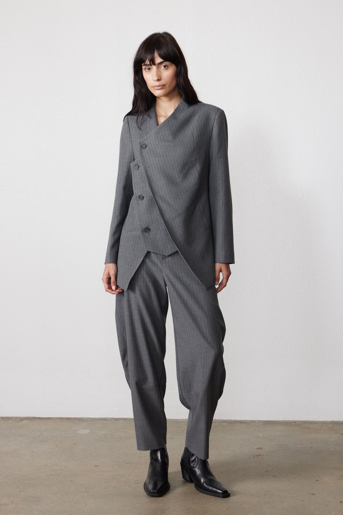 Gray pinstripe asymmetric suit jacket with angled front opening and long sleeves