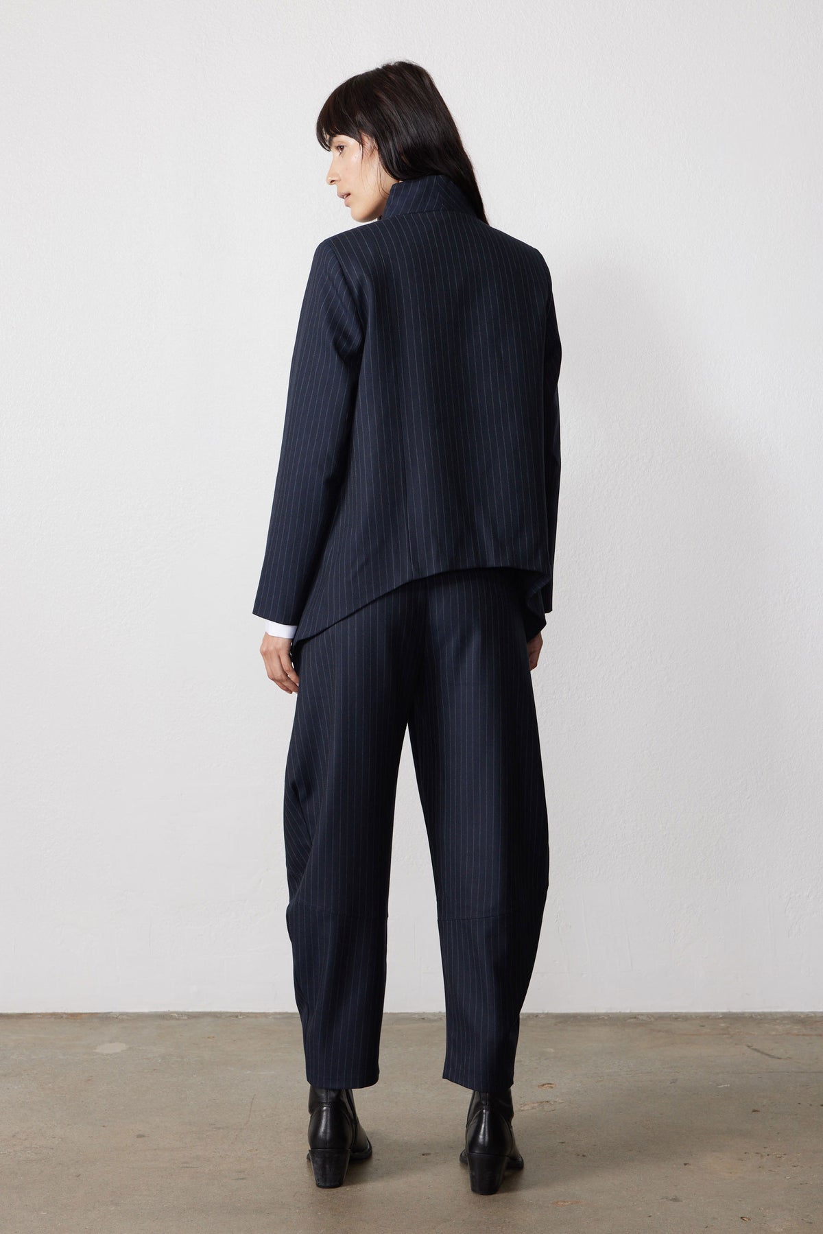 Navy pinstripe asymmetric suit jacket, back view, long sleeves and split hem