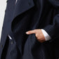 Navy pinstripe asymmetric jacket lapel and button placket, with welt pocket detail