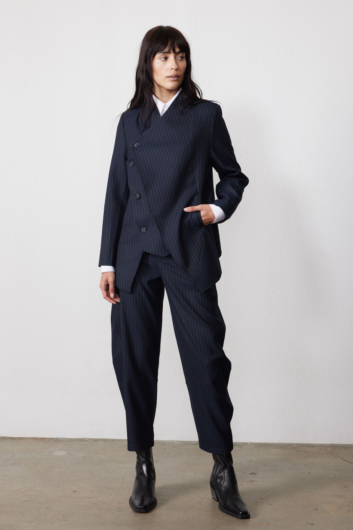 Navy pinstripe asymmetric suit jacket, front view, two-button closure and long sleeves