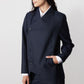 Navy pinstripe asymmetric suit jacket, side view, button closure and cuff detail