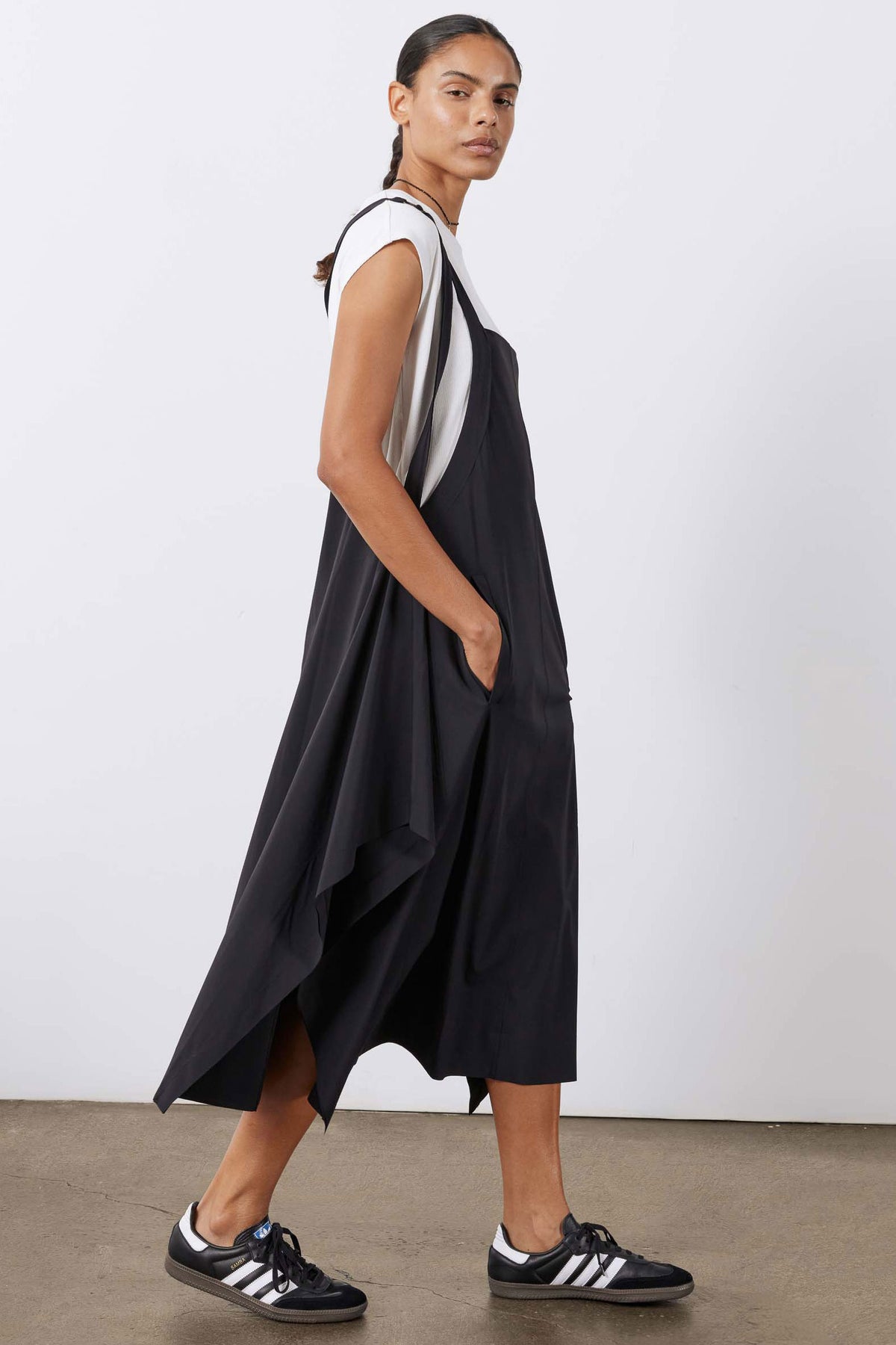 Black sleeveless sarafan dress with asymmetric hem and side drape.