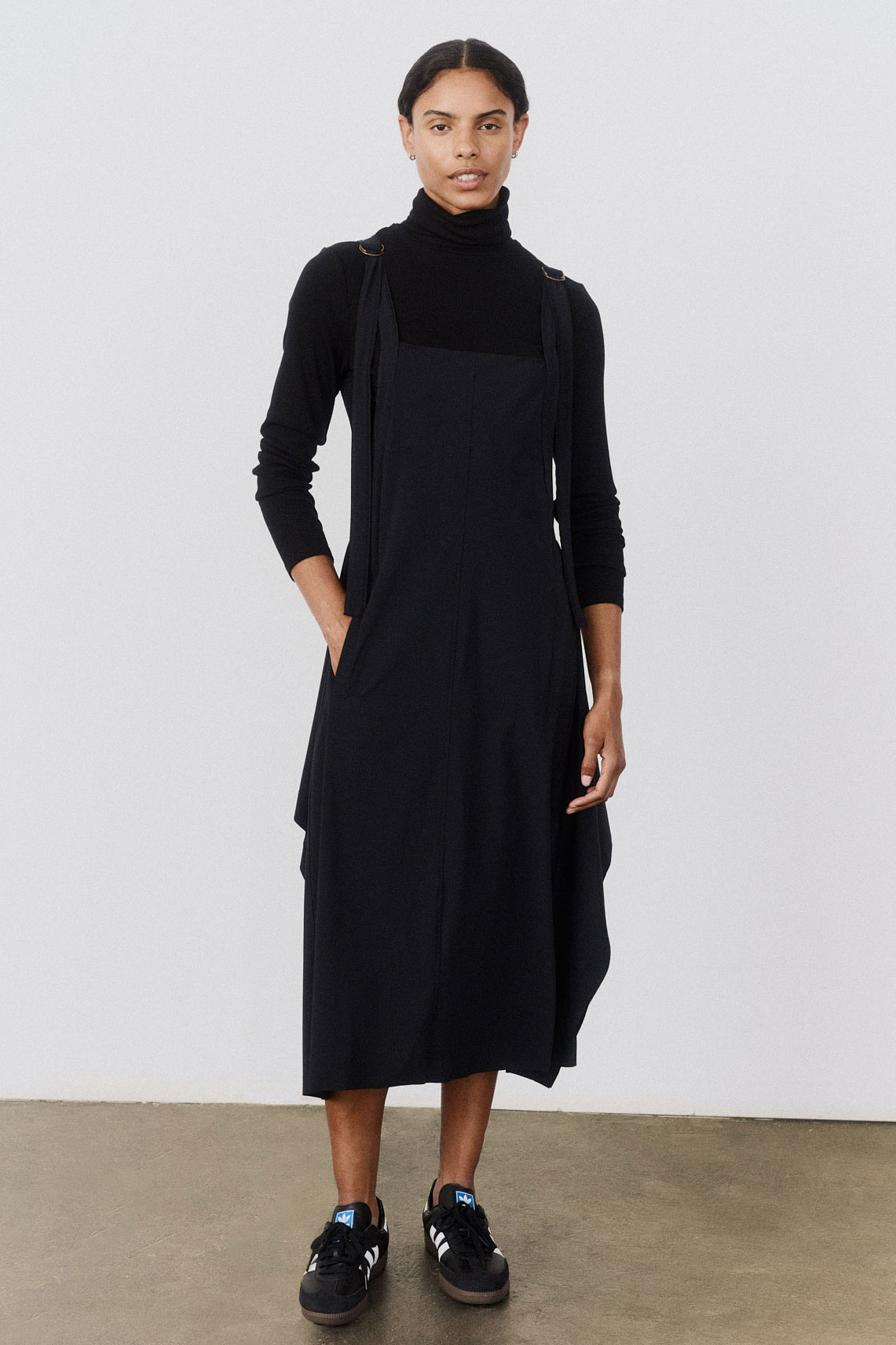 Black sleeveless midi sarafan dress with soft draped skirt and structured front bib.