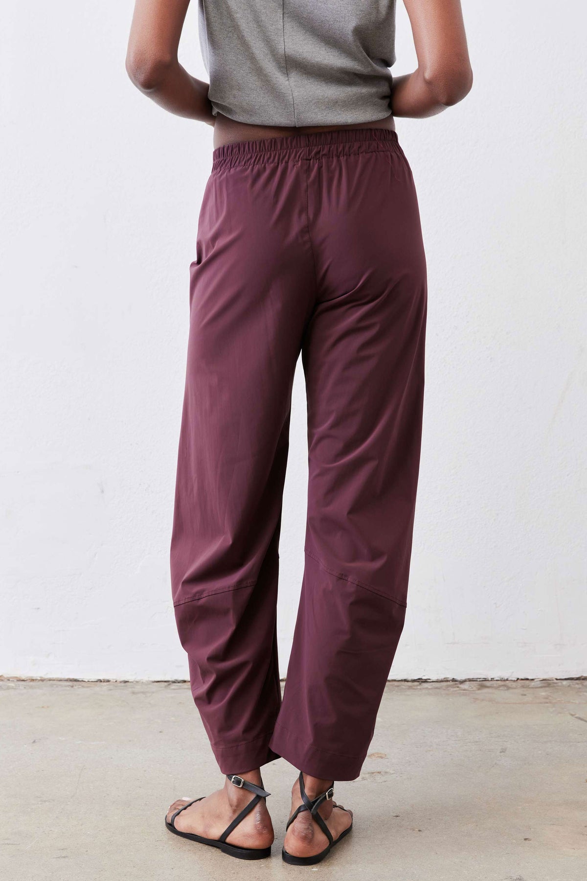 Aubergine work pants close-up: elastic waist with relaxed wide legs and ankle-length hem