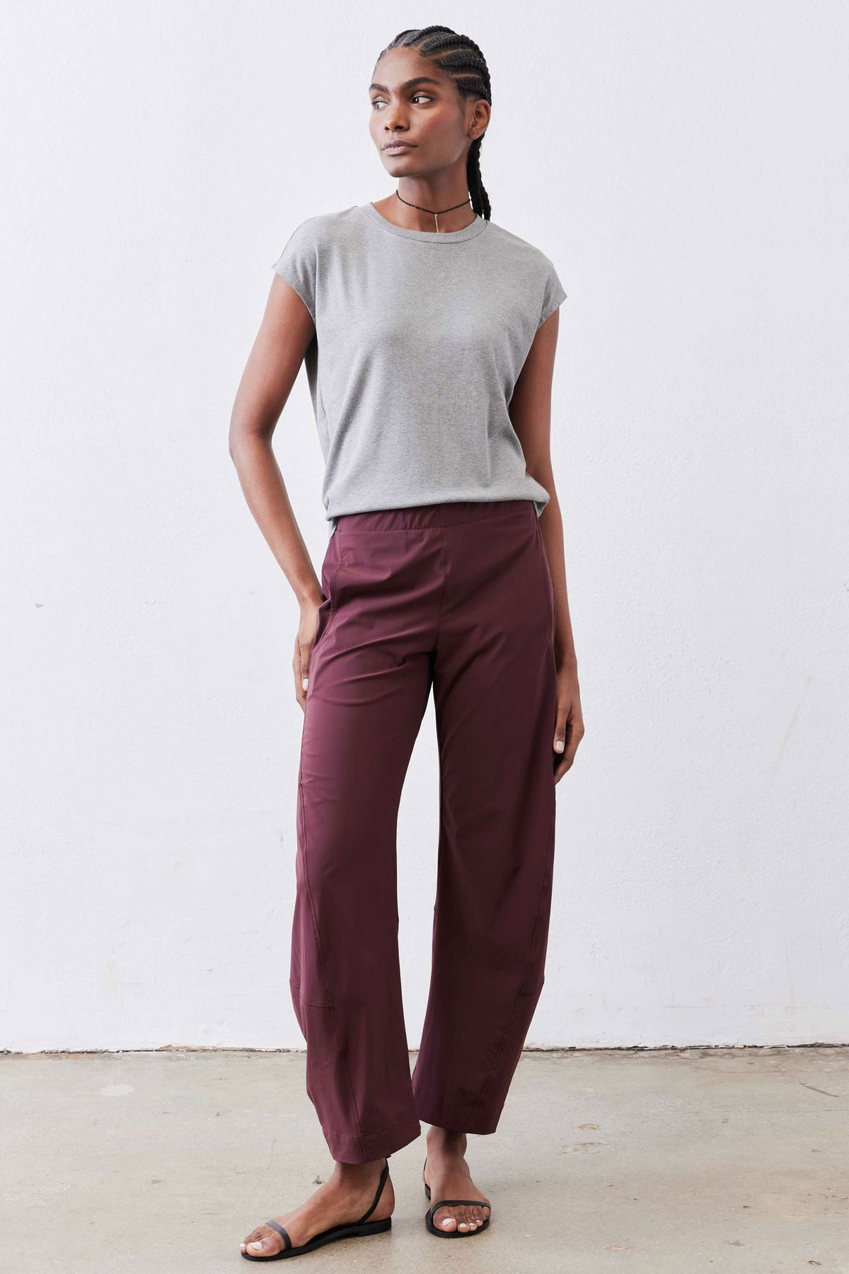 Aubergine work pants with drapey relaxed legs and elastic waistband, full-length look