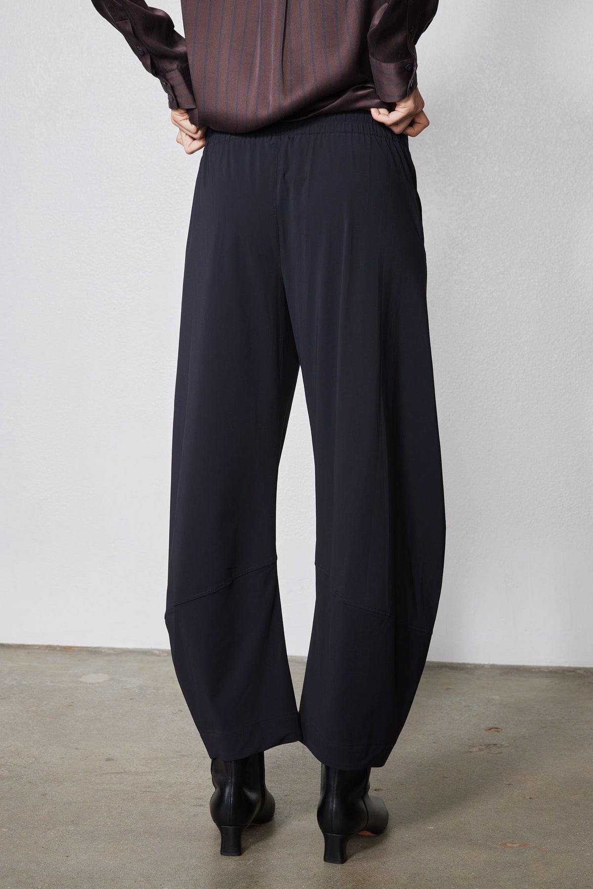 Black loose work pants with straight wide legs, back view