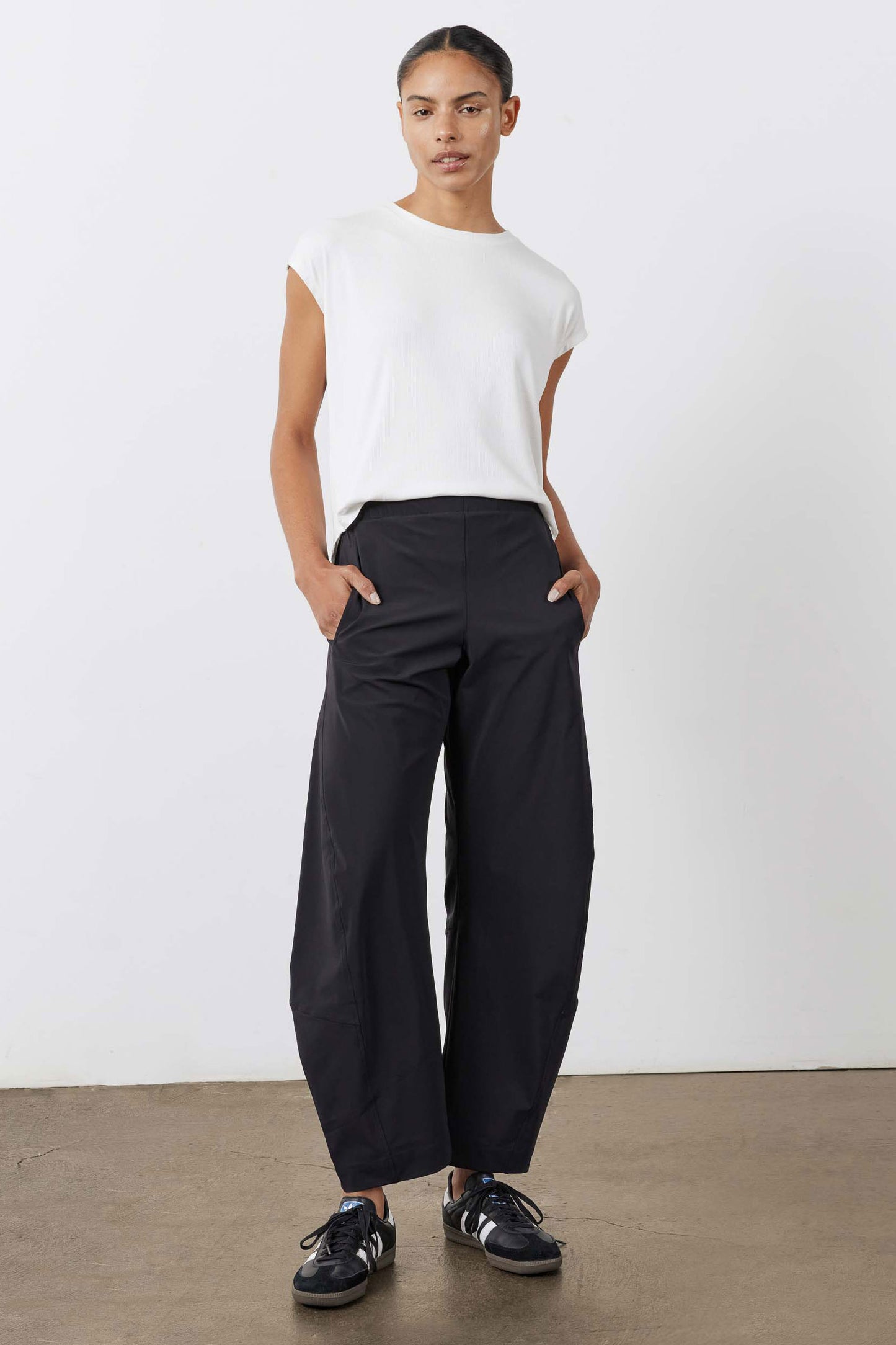 Black work pants with relaxed wide legs and elastic waistband, full-length front view