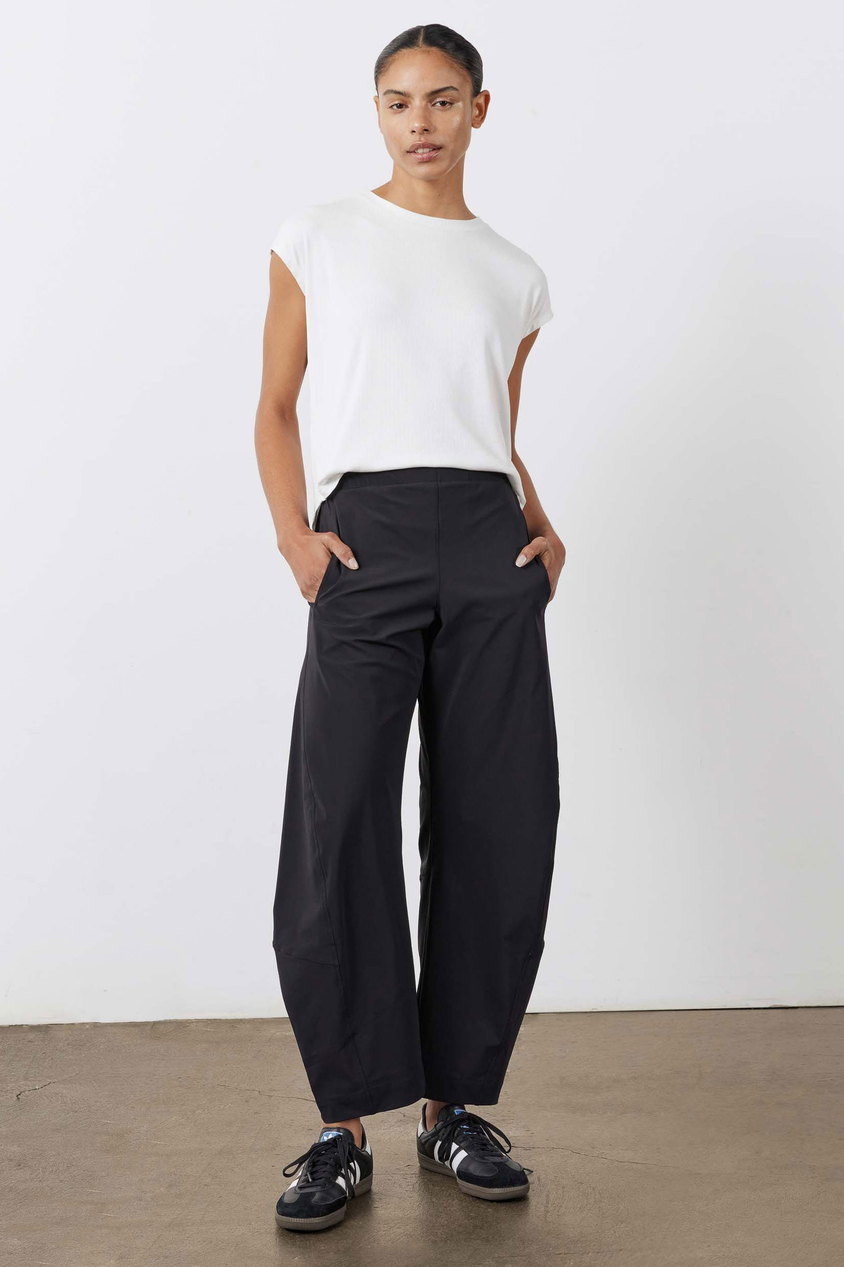 Black work pants with relaxed wide legs and elastic waistband, full-length front view