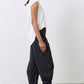 Black work pants with relaxed wide legs and elastic waistband, side profile view