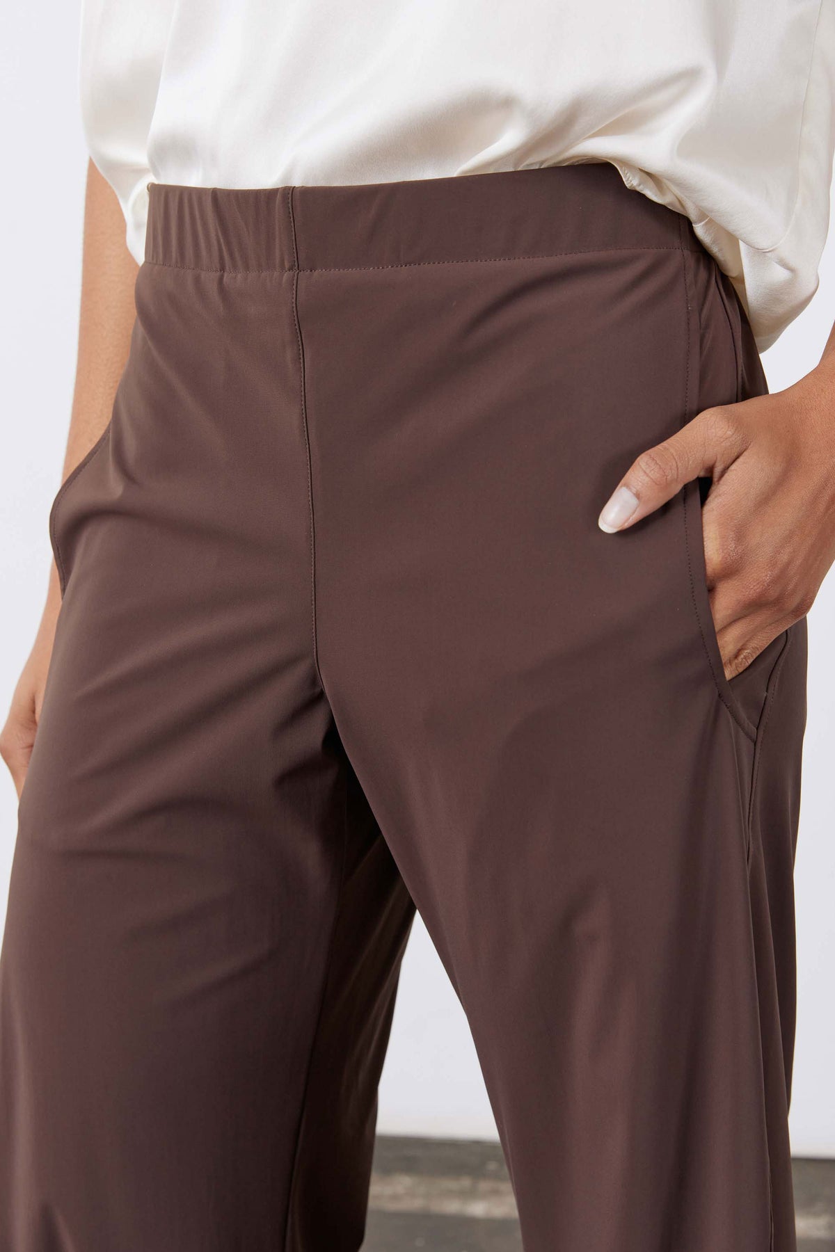 Coffee-brown work pants, elastic waist, relaxed wide-leg with side pockets.