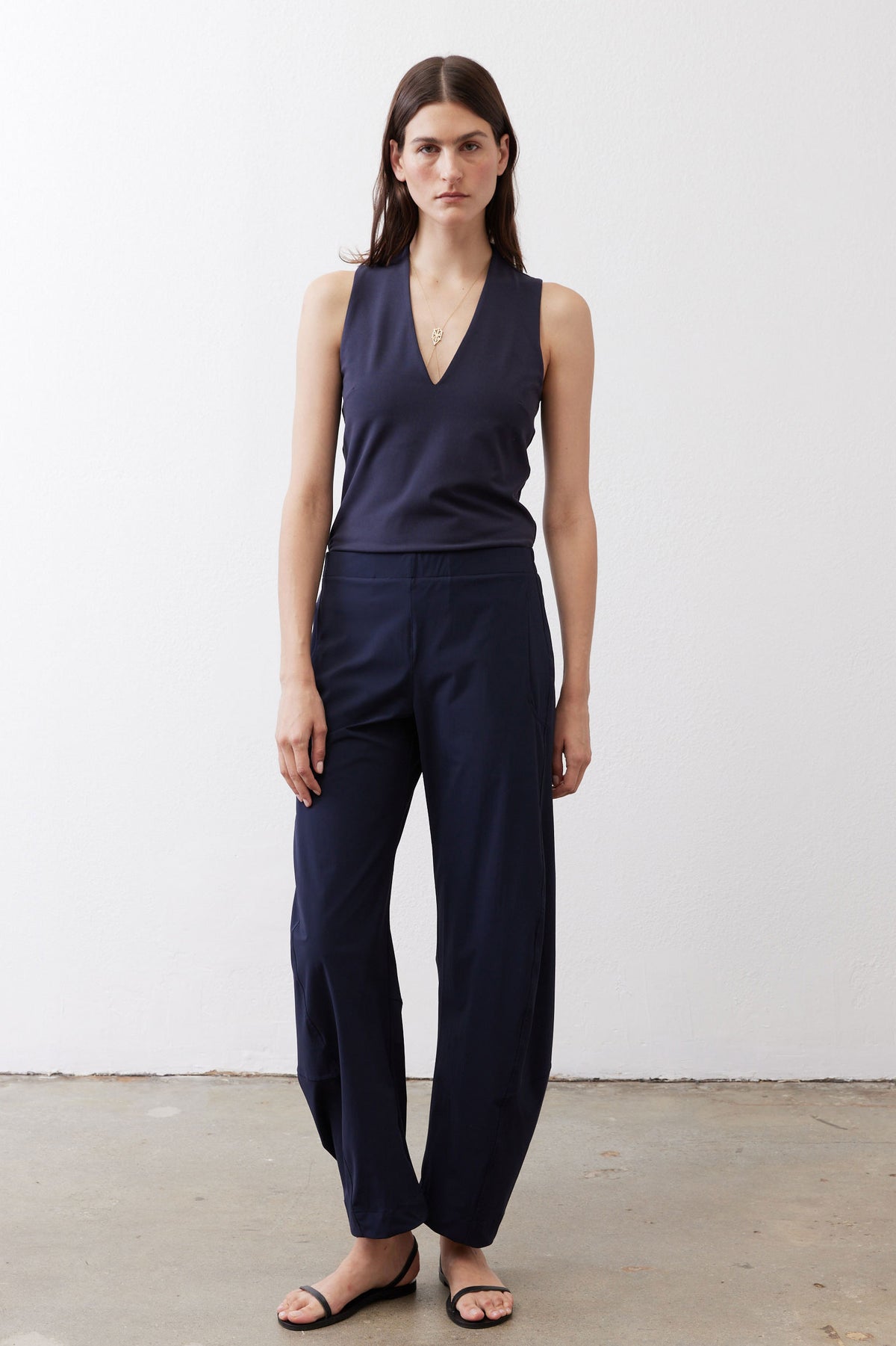 Loose navy work pants with V-shaped yoke seam and elastic waistband, wide straight legs