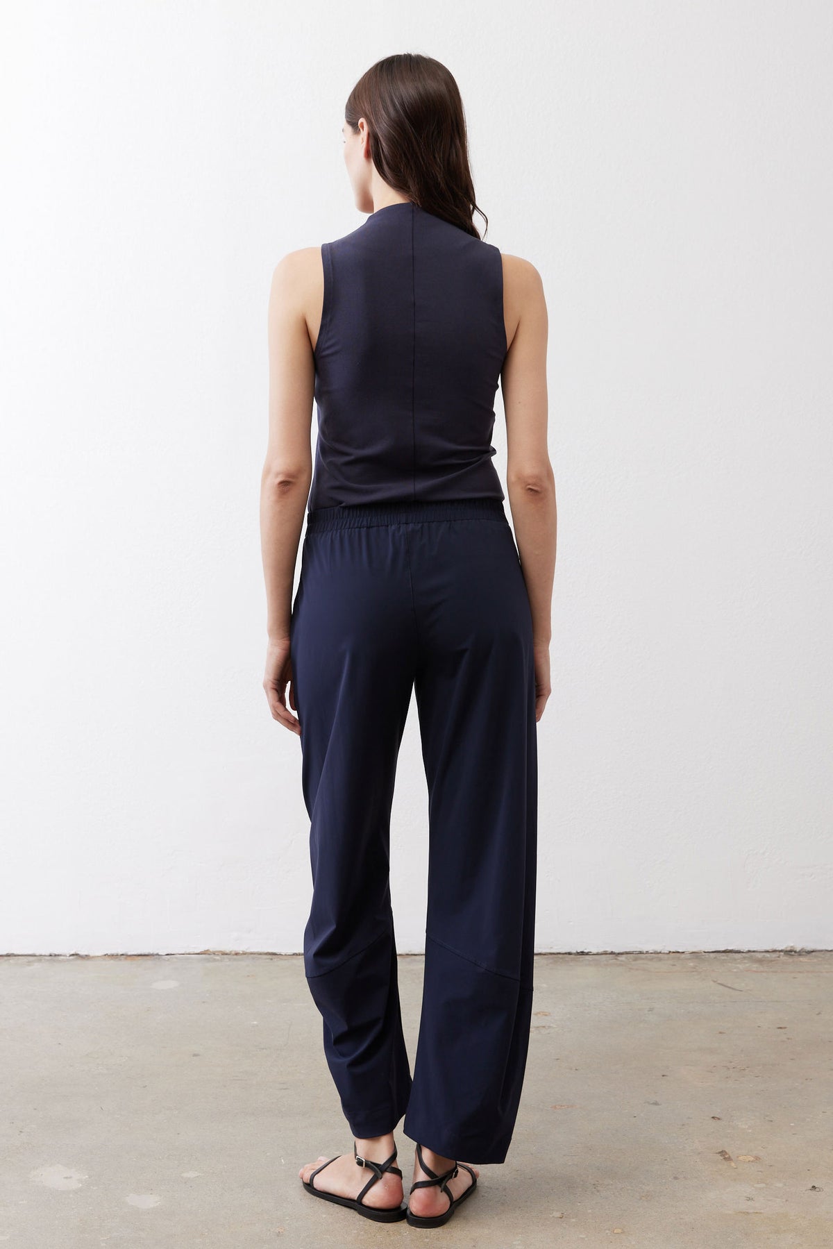 Back view of navy loose work pants with elastic waistband and wide leg opening
