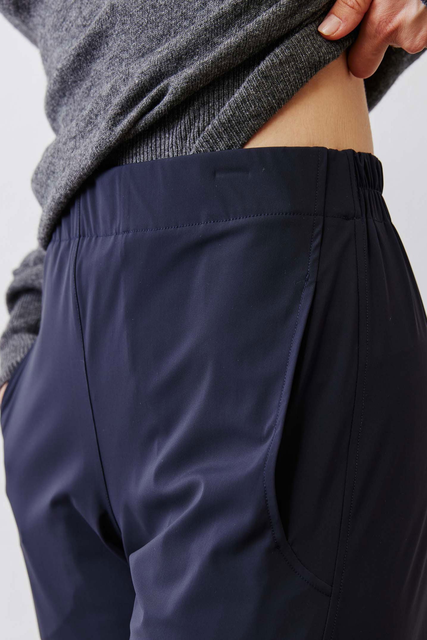 Dark navy work pants fabric close-up with elastic waistband and side seam.