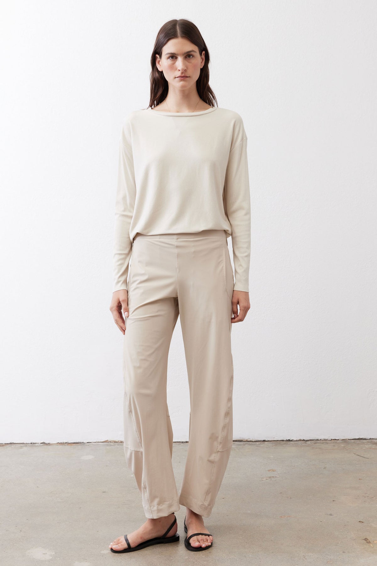 Light beige loose work pants with tapered straight legs and ankle-length hem