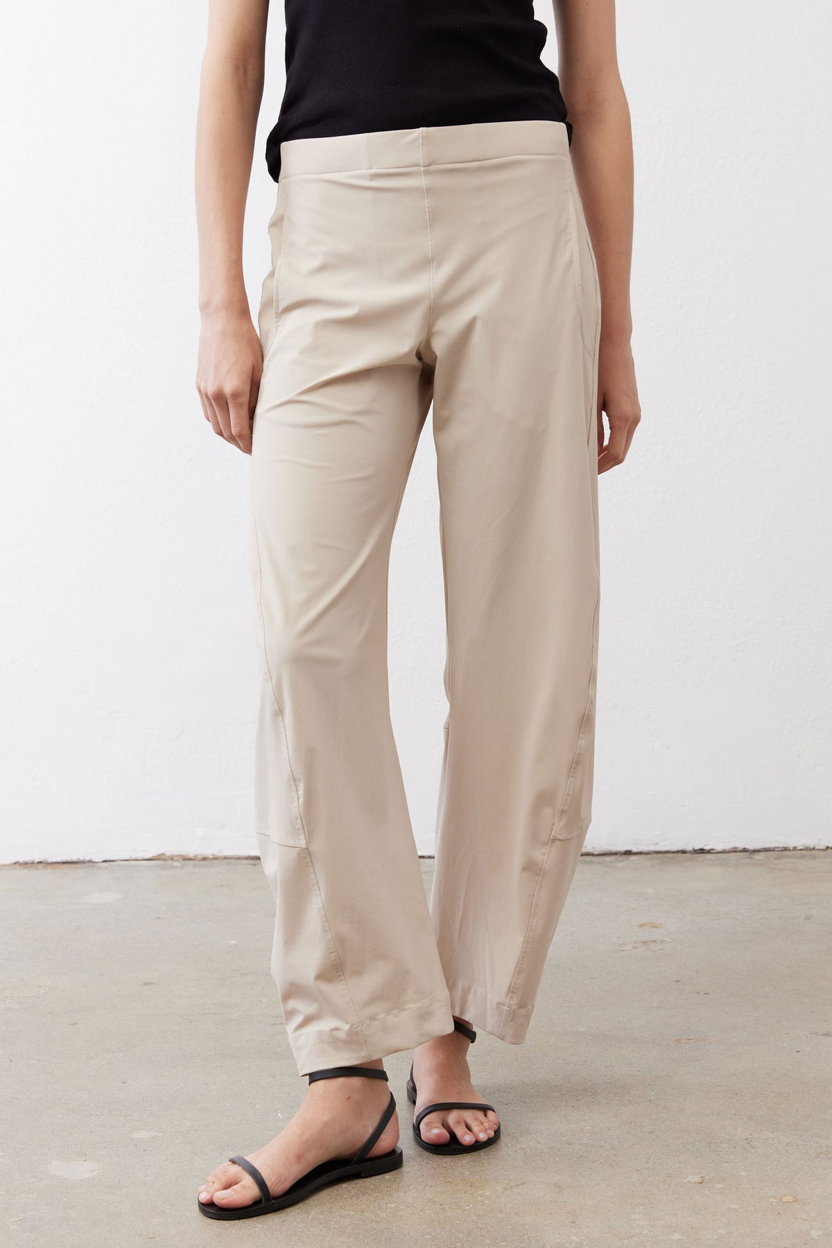 Light beige loose work pants with front slant pockets and ankle-length hem