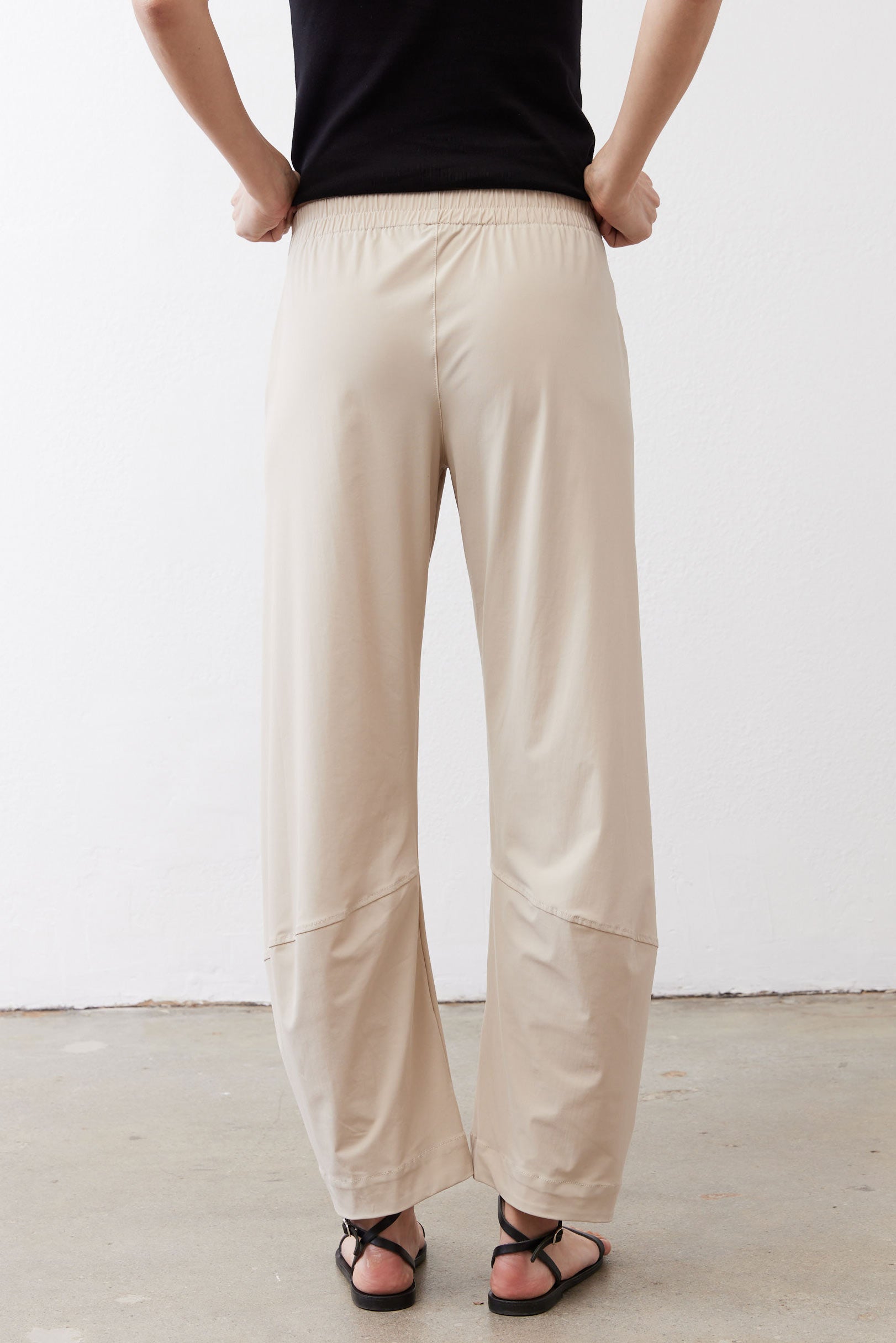Light beige work pants with elastic waistband and relaxed straight-leg back view